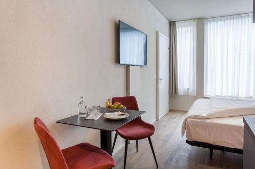 布鲁格Centurion Swiss Quality Towerhotel Windisch的配有桌椅和床的房间