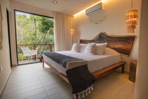 图卢姆Luxury Condos Macondo Tulum的一间带大床的卧室和一个阳台