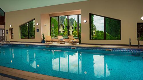 奥兰莫尔戈尔韦奥兰莫尔小屋会议及休闲中心酒店的一个带椅子和窗户的大型游泳池