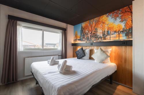 阿姆斯特丹布特尔酒店的卧室配有一张白色大床,墙上挂有绘画作品