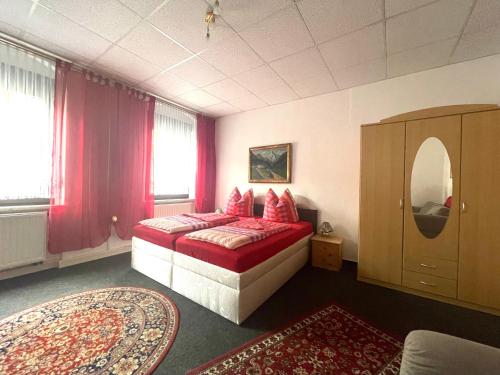 梅森Ferienwohnung NEUMANN a.d. Porzellan-Manufaktur的一间卧室配有红色枕头的床