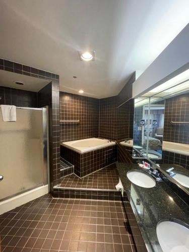 黑格斯敦Apm Inn & Suites的浴室配有两个盥洗盆和浴缸。