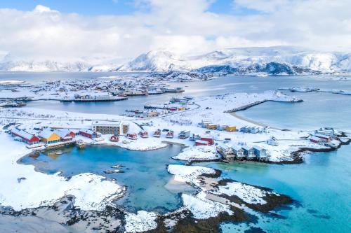索玛若伊Sommarøy Arctic Hotel Tromsø的享有小镇的空中景色,那里有雪覆盖的山脉