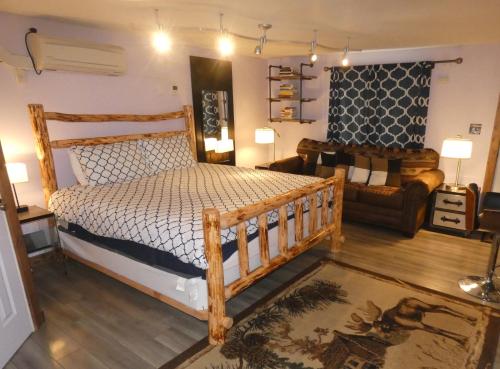 西黄石Yellowstone Motel - Adults Only - All rooms have kitchens的一间卧室配有一张木床和一张沙发