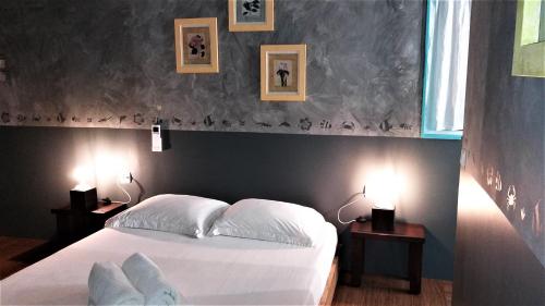 波拉波拉夕阳山别墅的一间卧室配有一张白色的床和两张带台灯的桌子。