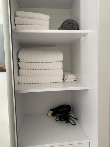 直布罗陀CP Top floor luxury studio的架子上带白色毛巾的衣柜