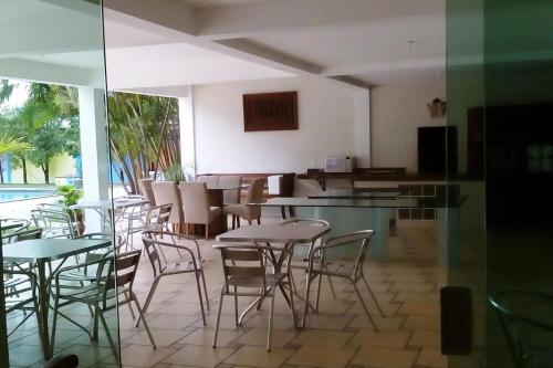 萨利诺波利斯Hotel Praia Bela的一间带桌椅的餐厅和一个游泳池