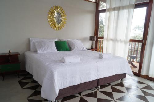 LamasIndano Art Lodge的卧室配有一张白色大床,墙上装有镜子