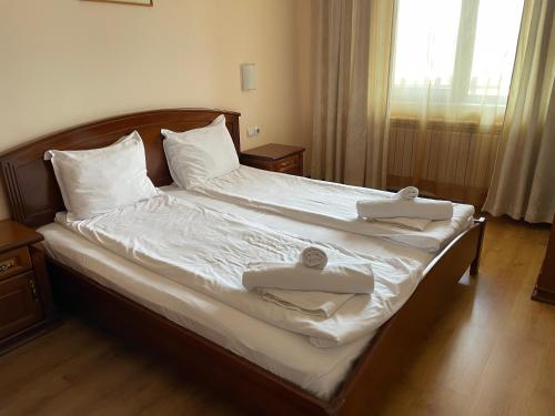 韦林格勒Комфортен апартамент DIANA в спа хотел 4 звезди, град Велинград的一间卧室配有一张床,上面有两条毛巾