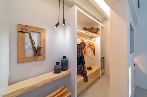 林都斯F Charm all Suites - Adults Only的步入式衣柜,配有木制架子和镜子