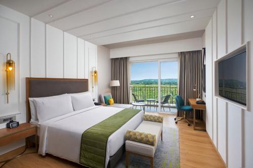 坎多林Holiday Inn Goa Candolim的酒店客房设有一张床和一个阳台。