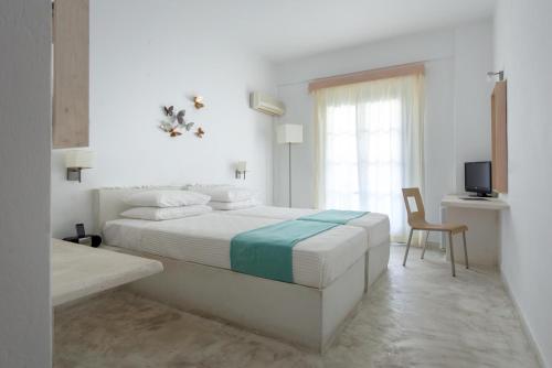 卡马利28酒店的一间白色卧室,配有床和电视