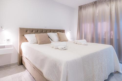 斯普利特Luxury rooms Green and Gold Split的卧室配有带毛巾的大型白色床