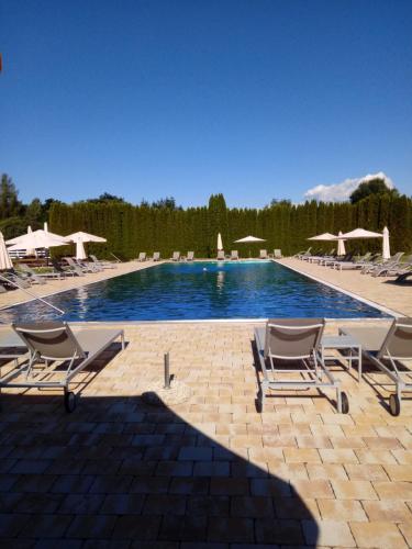 韦尔特湖畔克伦彭多夫古特德拉辛旅馆的一个带躺椅和遮阳伞的游泳池