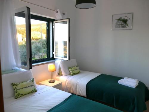 凡道Casa e piscina privada的一间卧室设有两张床和窗户。