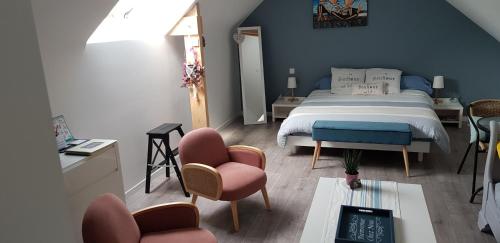巴登Au plaisir d’accueillir的一间卧室配有一张床、两把椅子和一张桌子