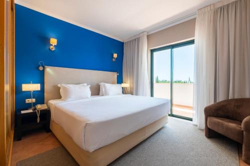 卡武埃鲁瓦乐瑞度假村的一间卧室设有一张大床和蓝色的墙壁