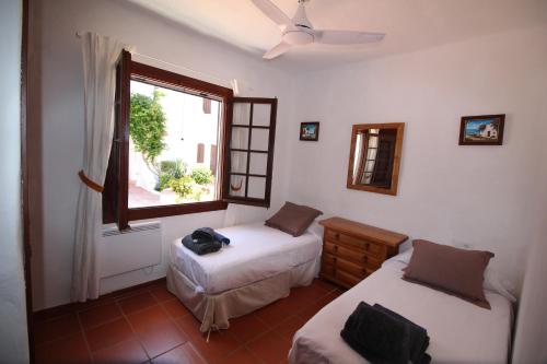福尔内利斯Casa Cristalina Menorca的一间卧室设有两张床和窗户。