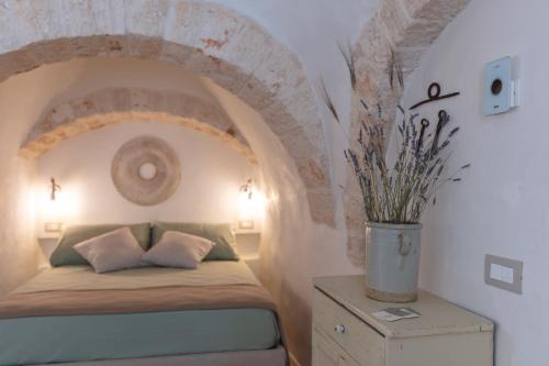 阿尔贝罗贝洛Trulli Magheia的一间卧室设有一张带拱形天花板的床