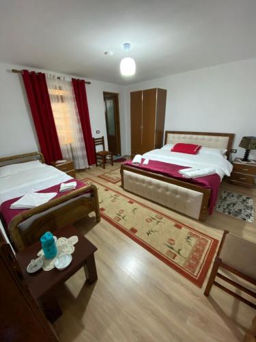 瓦勒博内Guesthouse Mehmeti的一间大卧室,配有两张床和一张桌子