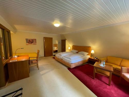 代特莫尔德兰德豪斯希尔施普龙旅馆的酒店客房,配有床和沙发