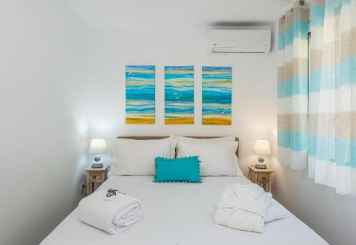 格利法达Waves Apartments Melody Glyfada的卧室配有带两盏灯的白色床