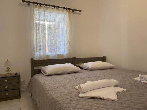 埃尔莫波利斯Casa Plakes的一间卧室配有两张带白色枕头的床和窗户。