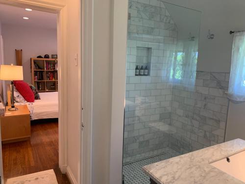 洛杉矶Beautiful airy architect-designed room and brand new private luxe bathroom的带淋浴的浴室和玻璃门