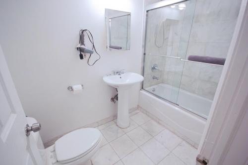 纽约一卧室超级公寓的浴室配有卫生间、盥洗盆和淋浴。