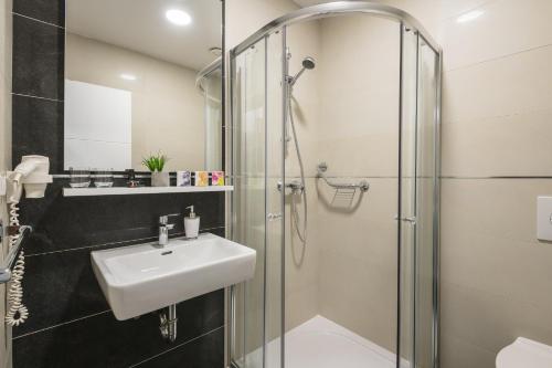 MočićiSky Airport Apartments的一间带水槽和淋浴的浴室