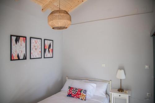 VóvikesRena's Panorama View House的一间卧室配有一张带灯和墙上照片的床。