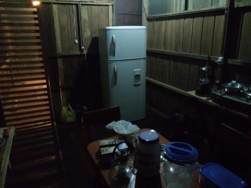 马尔多纳多港Don Jaime - Hostel的一间带桌子和冰箱的小厨房