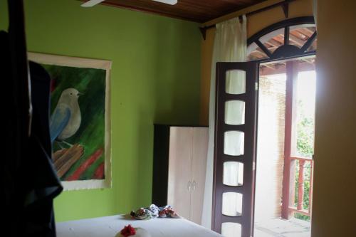 伊尔哈德博伊巴Pousada Ilha De Boipeba的卧室配有墙上的鸟画和窗户