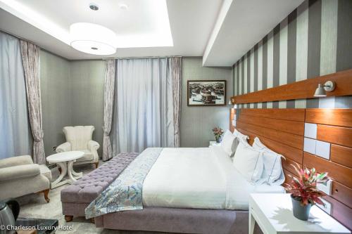 哈科特港Charleson Luxury Hotel的配有一张床和一把椅子的酒店客房