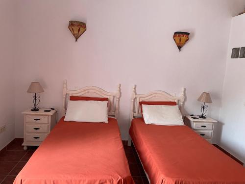 Comares万岁西班牙酒店的配有2张床位的带2个床头柜和台灯的客房