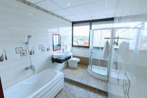Gia Nghĩa西贡达农酒店的带浴缸、卫生间和淋浴的浴室。