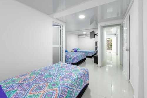 圣安德烈斯La isla inn的一间带两张床的卧室和走廊