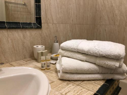 里昂Lyon 3 Triangle d'Or的浴室的柜台上摆放着一堆毛巾