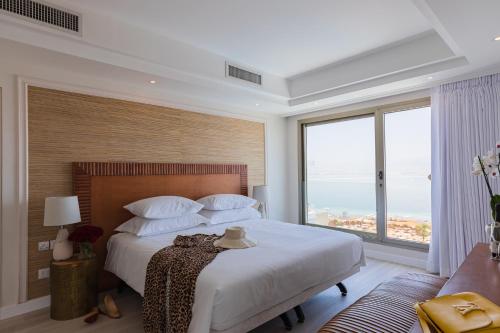 恩波其克Enjoy Dead Sea Hotel -Formerly Daniel的一间卧室设有一张大床和大窗户