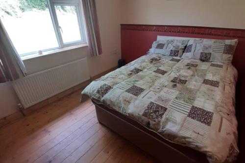卡文Lovely Innishmore Island Farmhouse的一间卧室配有床,床上装有被子