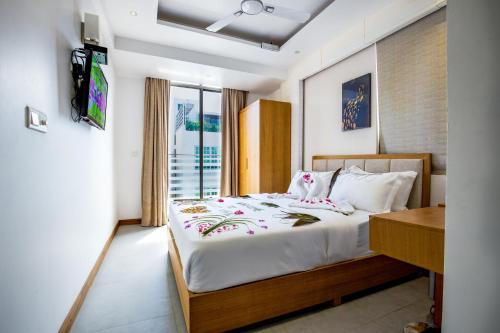 胡鲁马累Araamview的一间卧室配有一张床和一台电视