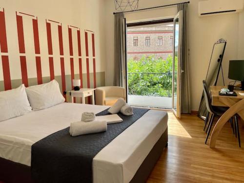 雅典Acropolis Museum Apartment的一间卧室配有一张床,上面有两条毛巾