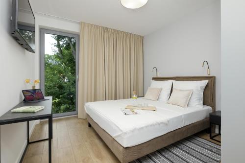 里沃Apartamenty Gryf Rewal的卧室设有一张白色大床和一扇窗户。