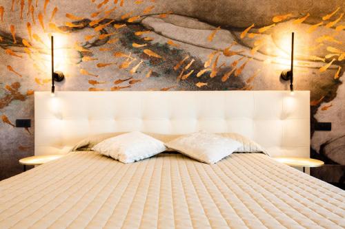 莱万托Bellevue - Rooms & Suites的卧室内的一张带两个枕头的白色床