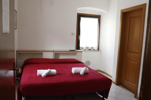科马诺泰梅B&B Amico的房间里的两张红色床上的毛巾