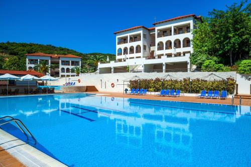 欧拉努波利斯Xenios Theoxenia Hotel的一座带蓝色椅子的大型游泳池和一座建筑