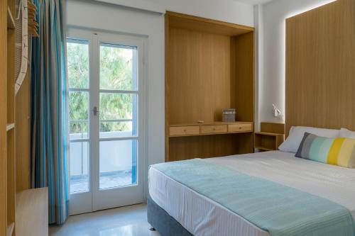拉斐那CHROMA Lodge Rafina的一间卧室设有一张床和一个大窗户