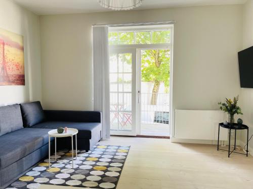 奥尔堡aday - 2 bedroom apartment with Patio的客厅配有蓝色的沙发和桌子