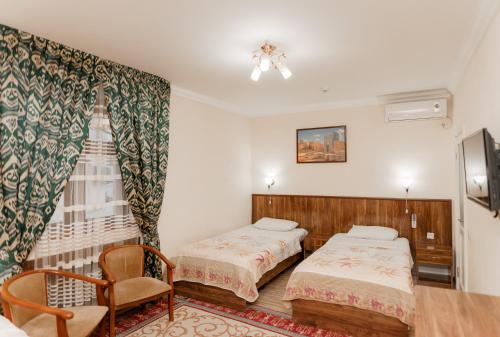 撒马尔罕迪秀达酒店的酒店客房,配有两张床和椅子