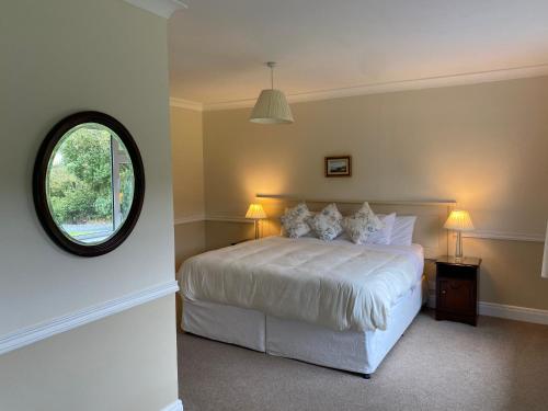 克利夫登Ardmore House的卧室配有白色的床和圆形窗户。